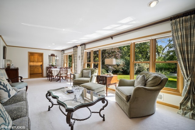 living room featuring light colored carpet, a wealth of natural light, and ornamental molding