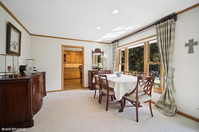 dining room featuring crown molding, recessed lighting, baseboards, and light carpet