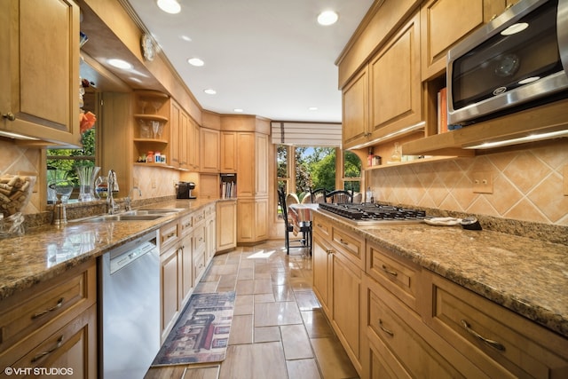 kitchen with sink, decorative backsplash, appliances with stainless steel finishes, and light stone counters