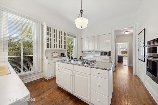 kitchen featuring pendant lighting, stainless steel appliances, and white cabinetry