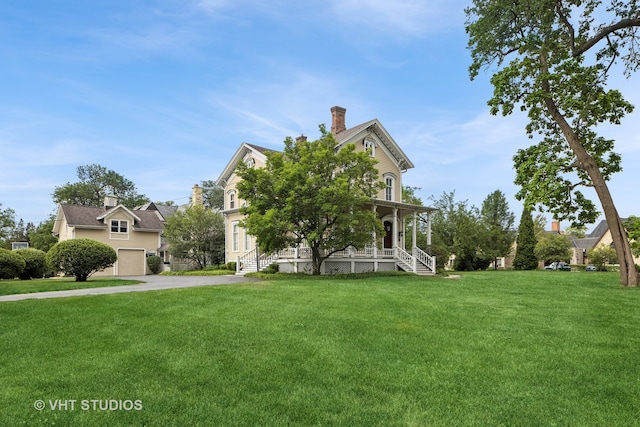 view of front facade with a garage, covered porch, and a front yard