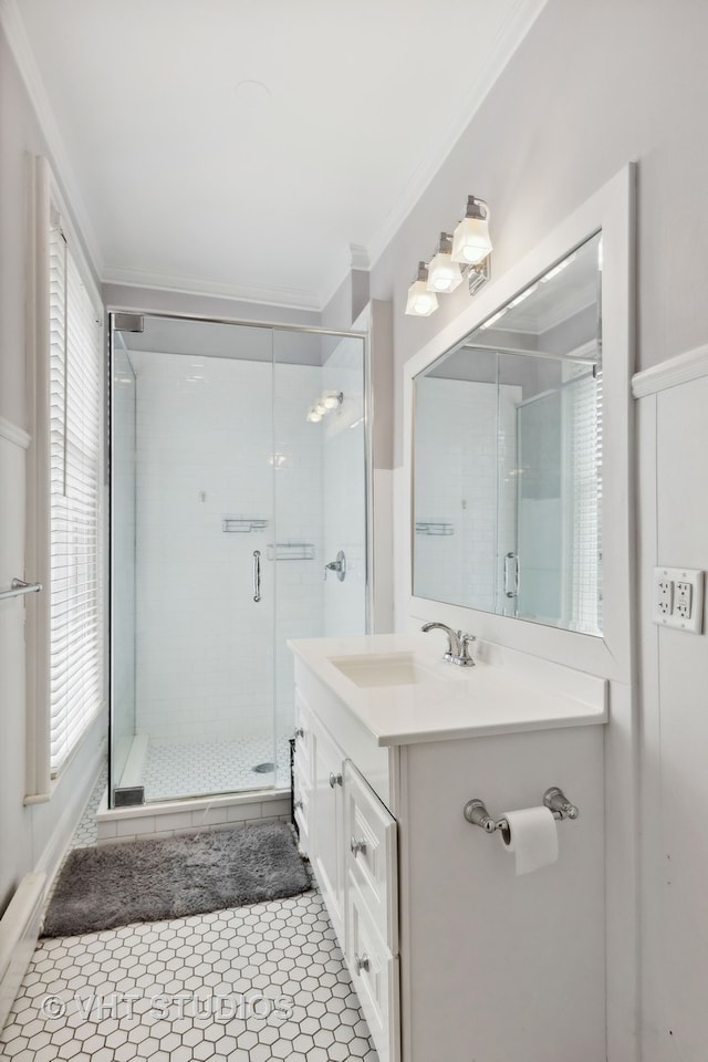 bathroom featuring tile patterned flooring, a shower with shower door, ornamental molding, and vanity