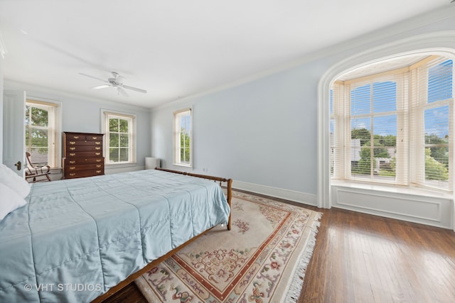 bedroom featuring ceiling fan, dark hardwood / wood-style flooring, and crown molding