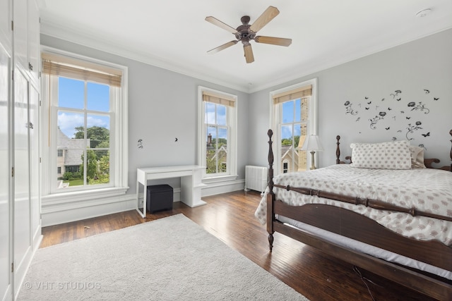 bedroom featuring dark hardwood / wood-style flooring, ceiling fan, radiator heating unit, and ornamental molding