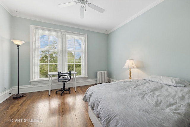 bedroom featuring hardwood / wood-style flooring, ceiling fan, radiator, and multiple windows