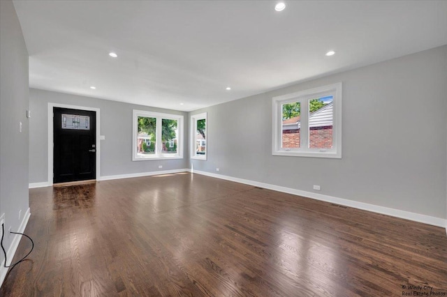 unfurnished living room with dark wood-type flooring