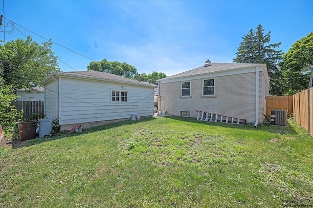 back of property featuring a lawn and central AC