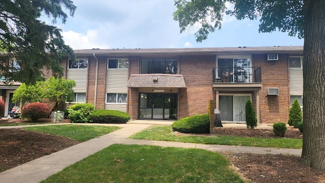 multi unit property with a balcony and a front lawn