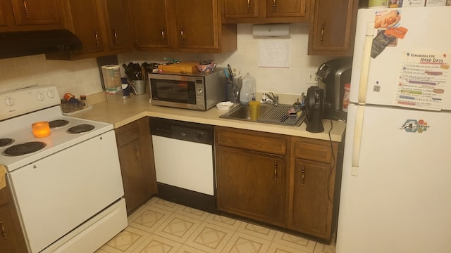 kitchen featuring decorative backsplash, range hood, white appliances, and sink