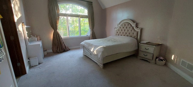 carpeted bedroom with vaulted ceiling and multiple windows