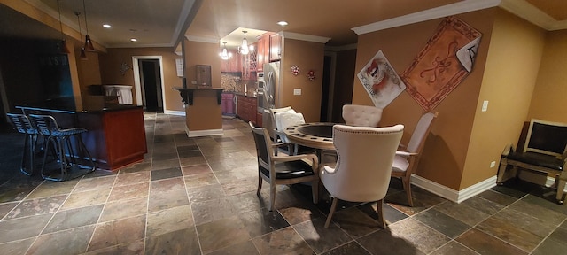 dining area featuring crown molding and dark tile flooring