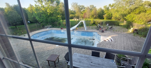 view of swimming pool featuring a water slide and a patio