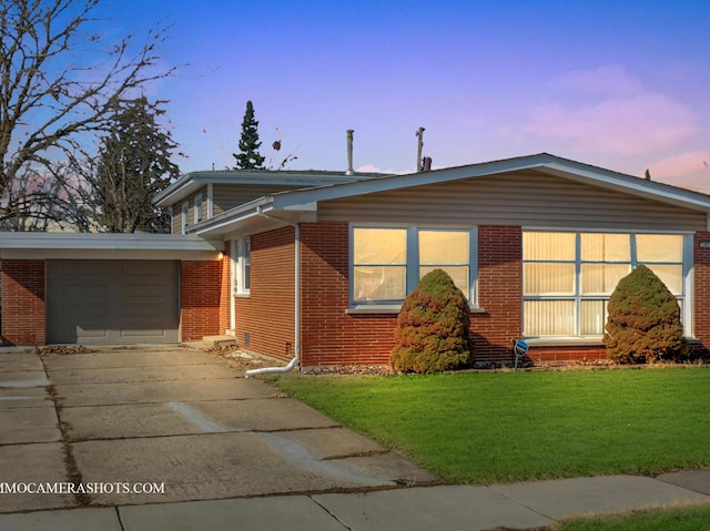 view of front of house featuring a front lawn, concrete driveway, and brick siding