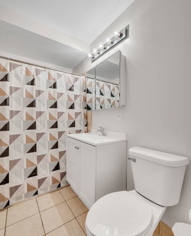 bathroom with toilet, vanity, and tile patterned floors