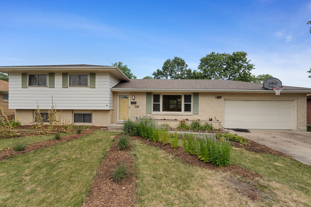 tri-level home with a front yard and a garage