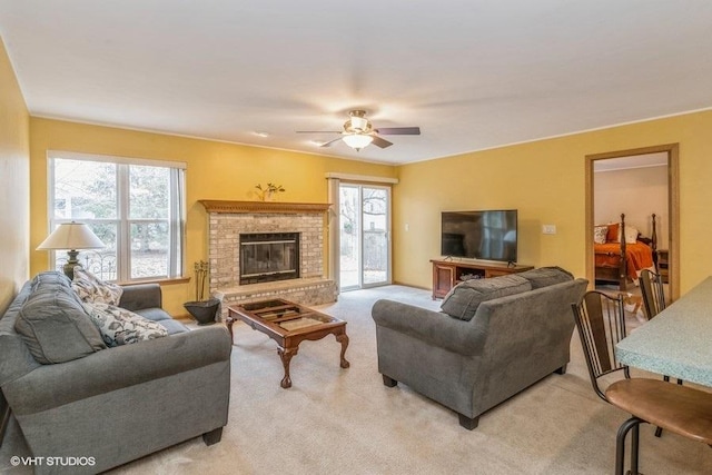 carpeted living room with a brick fireplace and ceiling fan