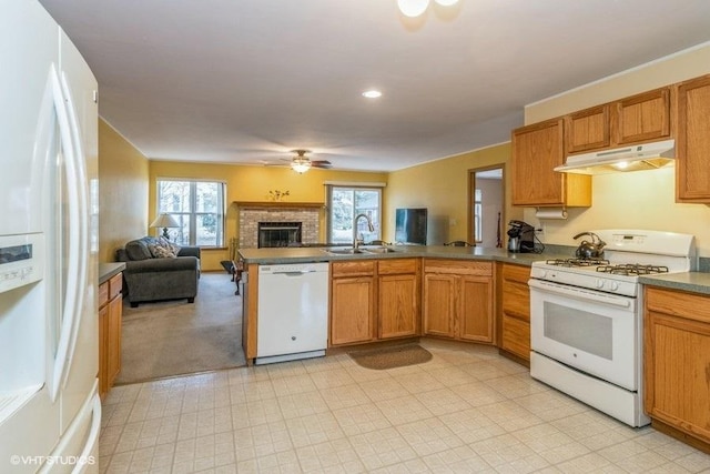 kitchen featuring a fireplace, sink, ceiling fan, kitchen peninsula, and white appliances