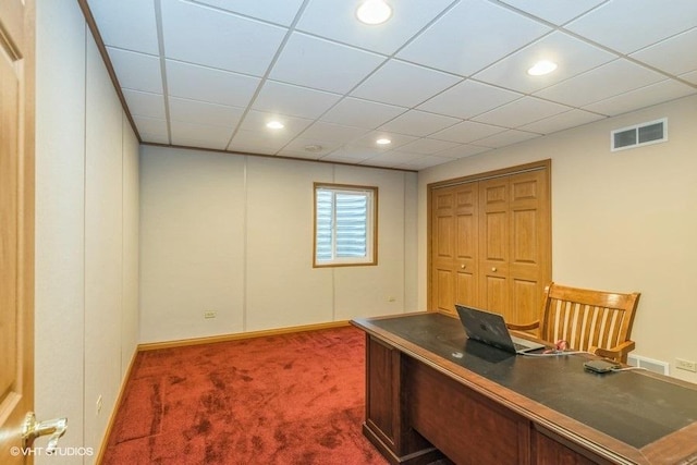 carpeted home office with a drop ceiling