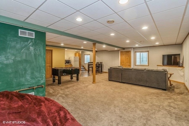 carpeted living room with a drop ceiling