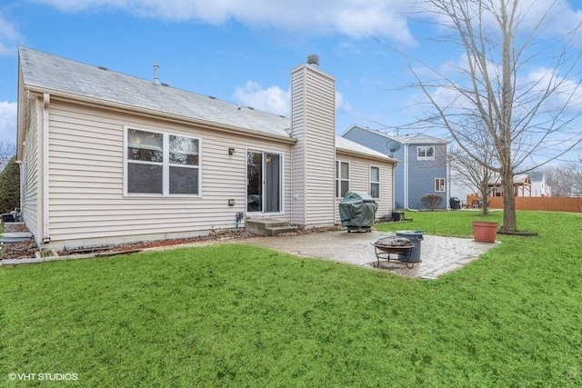 back of property featuring a yard, a patio area, and an outdoor fire pit