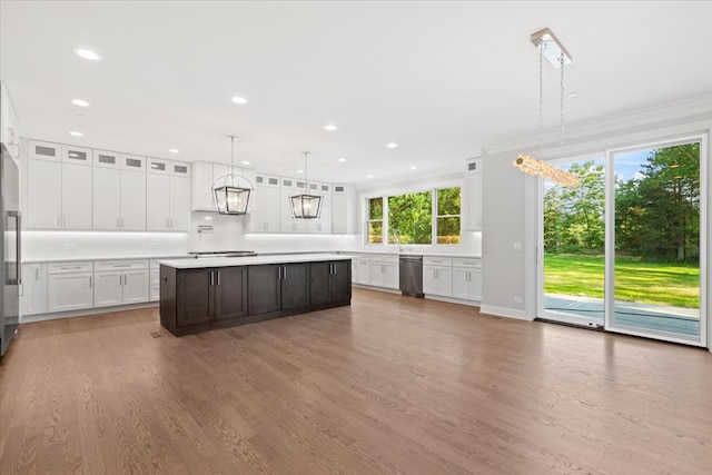 kitchen featuring decorative light fixtures, a center island, white cabinetry, and ornamental molding