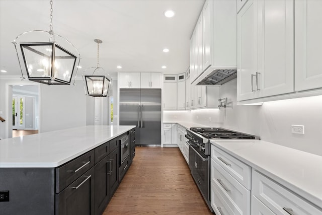 kitchen with pendant lighting, high quality appliances, a chandelier, a center island, and white cabinetry