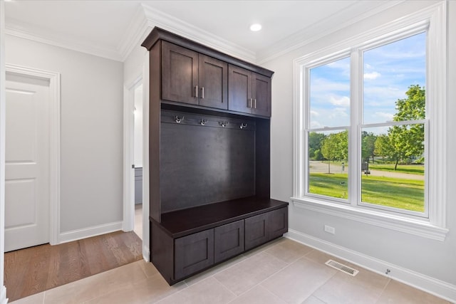 mudroom with ornamental molding and light tile patterned floors