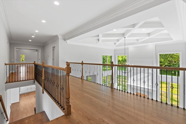 hall featuring coffered ceiling, beamed ceiling, crown molding, a chandelier, and light hardwood / wood-style floors