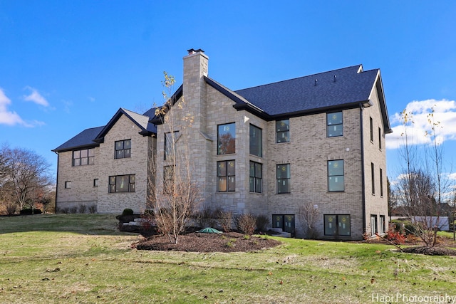 rear view of property featuring a lawn