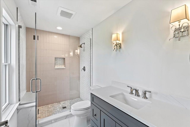 bathroom featuring vanity, toilet, and a shower with shower door