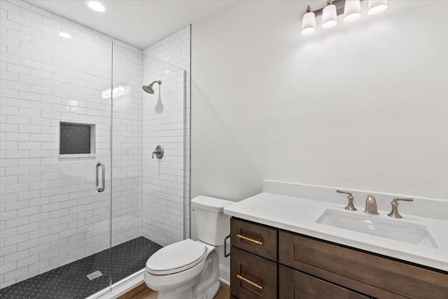 bathroom with an enclosed shower, vanity, and toilet