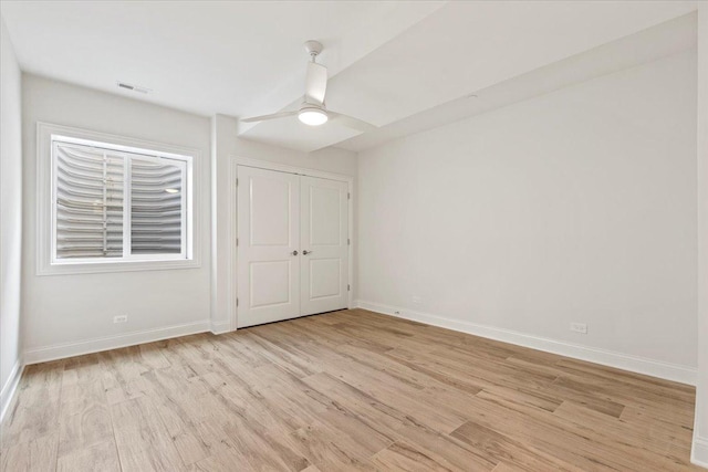 unfurnished bedroom featuring ceiling fan, a closet, and light hardwood / wood-style floors