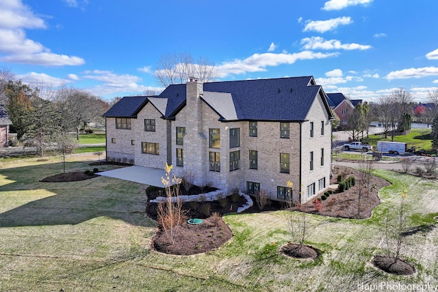 back of property with a yard and a patio