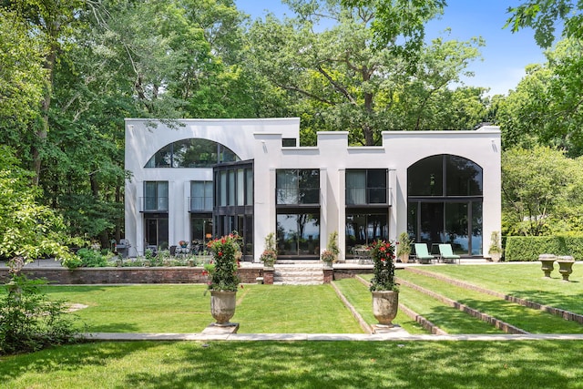 rear view of property featuring a lawn