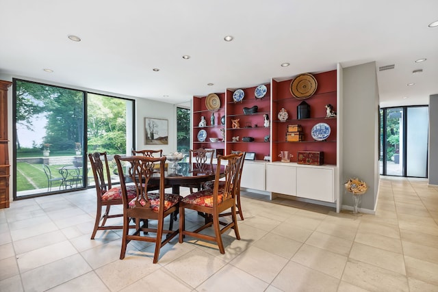 dining space with a wall of windows and light tile flooring