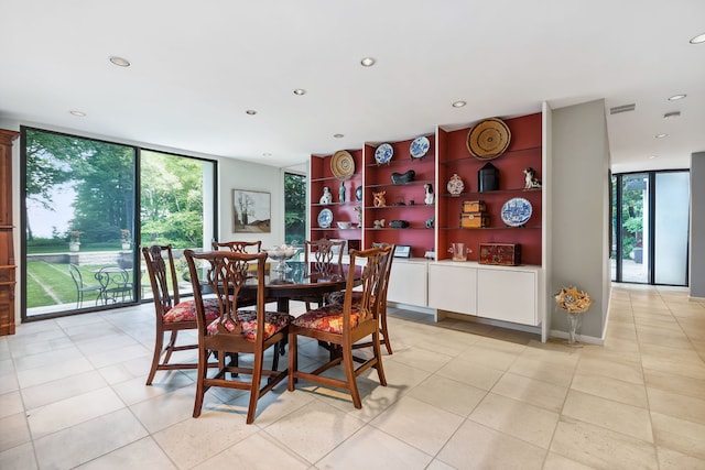 dining room featuring a wealth of natural light, a wall of windows, and light tile patterned flooring