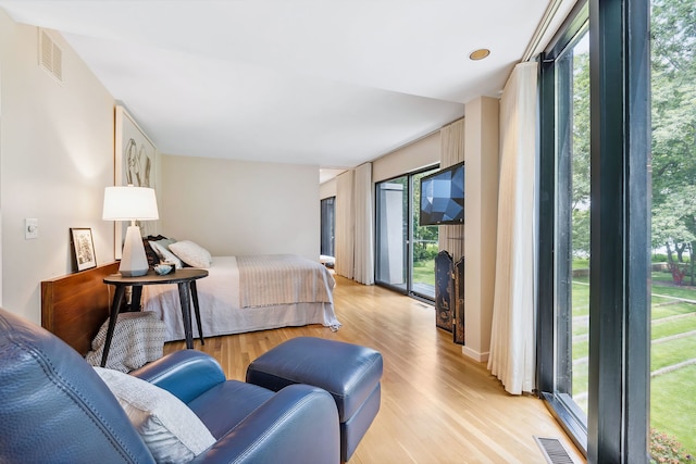 bedroom with access to exterior and light hardwood / wood-style flooring