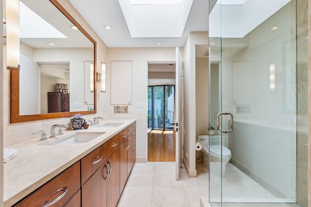 bathroom with double sink vanity, walk in shower, tile floors, a skylight, and toilet