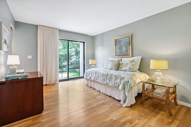 bedroom with access to exterior and light wood-type flooring