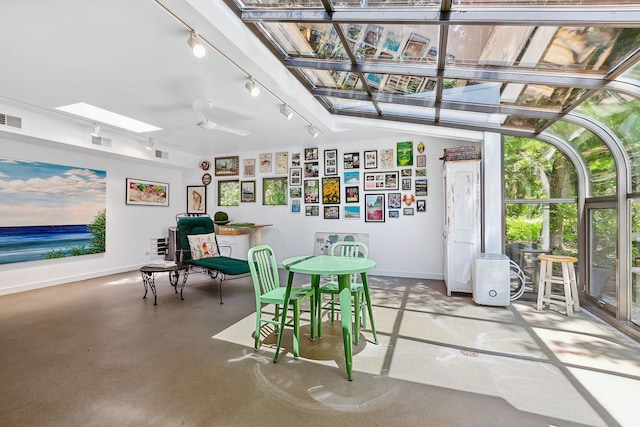 sunroom / solarium with a skylight, track lighting, and ceiling fan