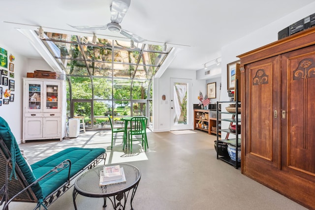 sitting room with plenty of natural light, ceiling fan, and concrete flooring