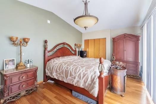 bedroom featuring light wood-type flooring and vaulted ceiling