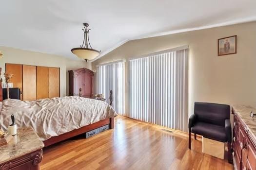 bedroom with lofted ceiling and light hardwood / wood-style flooring