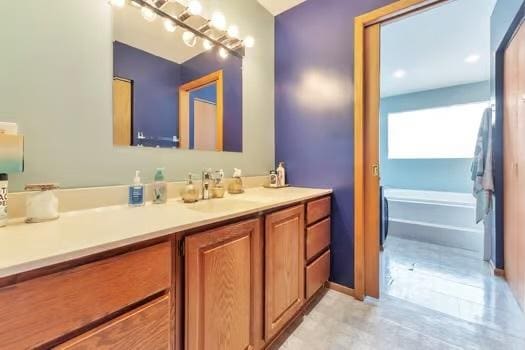 bathroom with vanity and a washtub