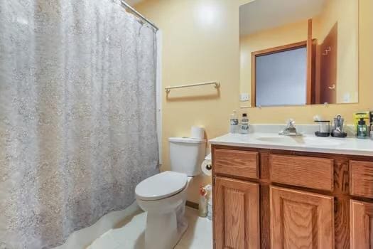 bathroom with toilet, vanity, and a shower with shower curtain