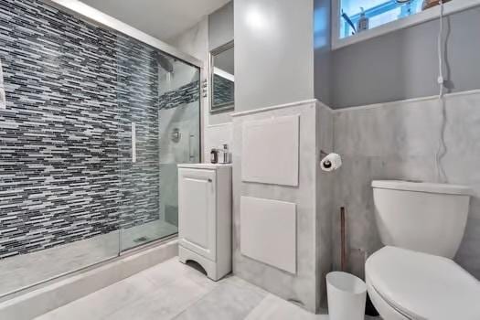 bathroom with toilet, tile walls, walk in shower, and vanity