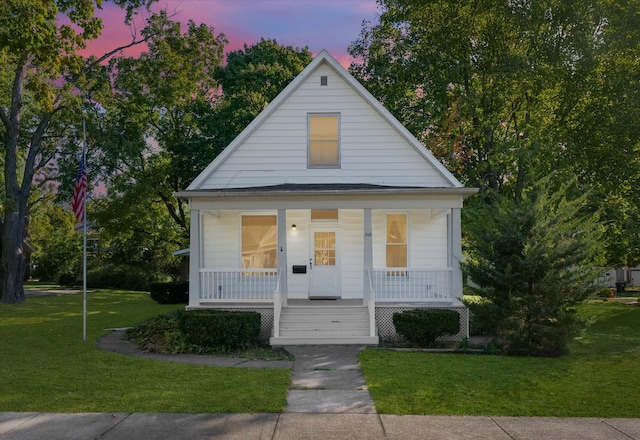 view of front of home with covered porch and a yard