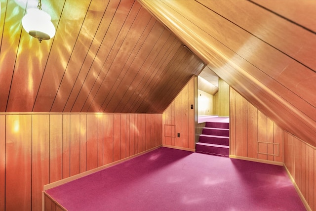 bonus room with lofted ceiling, wood walls, and carpet floors