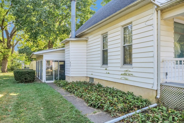 view of side of home featuring a lawn and a sunroom