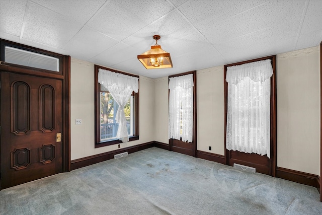 carpeted entrance foyer with a drop ceiling